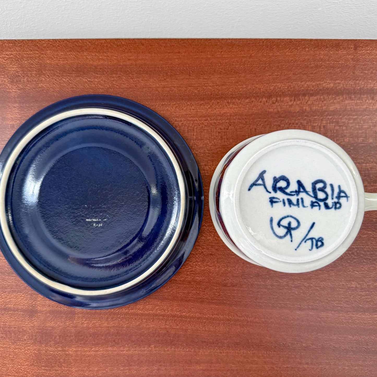 Bottom view of Arabia Finland Anemone Tea Cup with Blue Saucer showing the deep blue saucer and the cup’s ceramic base with clear Arabia Finland maker’s marks.