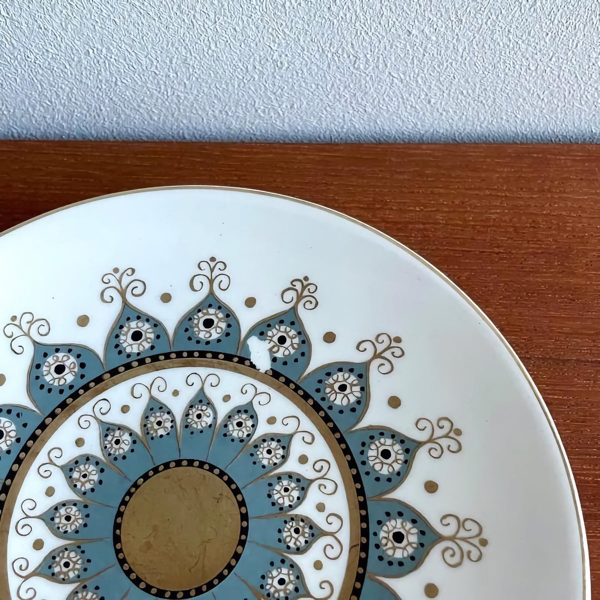 Vintage Arabia Finland Katinka Espresso Cup Trio Set cake plate with intricate blue and gold floral pattern, showcasing Scandinavian ceramic craftsmanship on wooden surface.