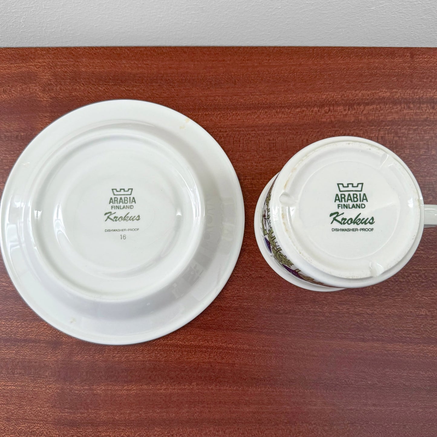 Back view of Arabia Finland Krokus Coloured Tea Cup with Saucer showing vintage maker’s marks and dishwasher-proof labels on white ceramic drinkware.