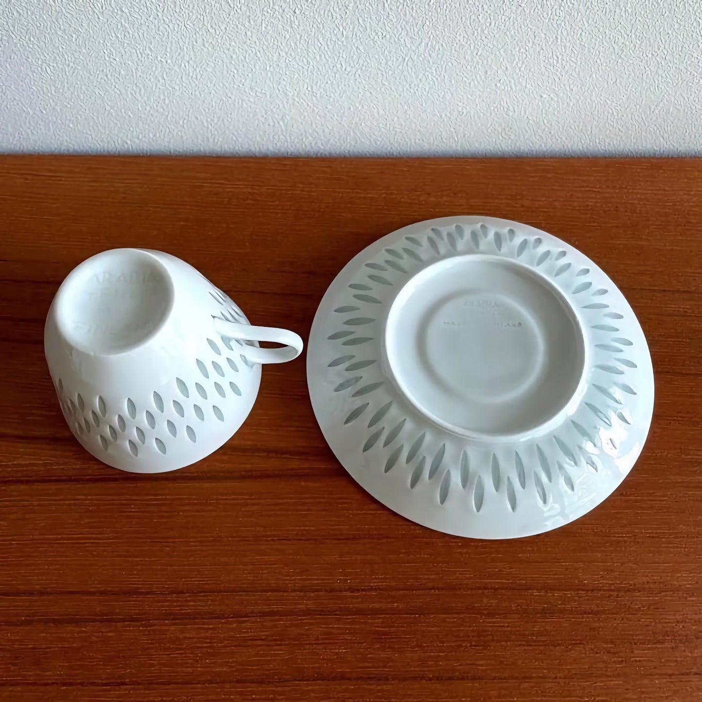 Arabia Finland Rice Porcelain Coffee Cup Trio Set showing the underside of a white cup and matching saucer with a subtle grey leaf pattern, crafted from fine porcelain.