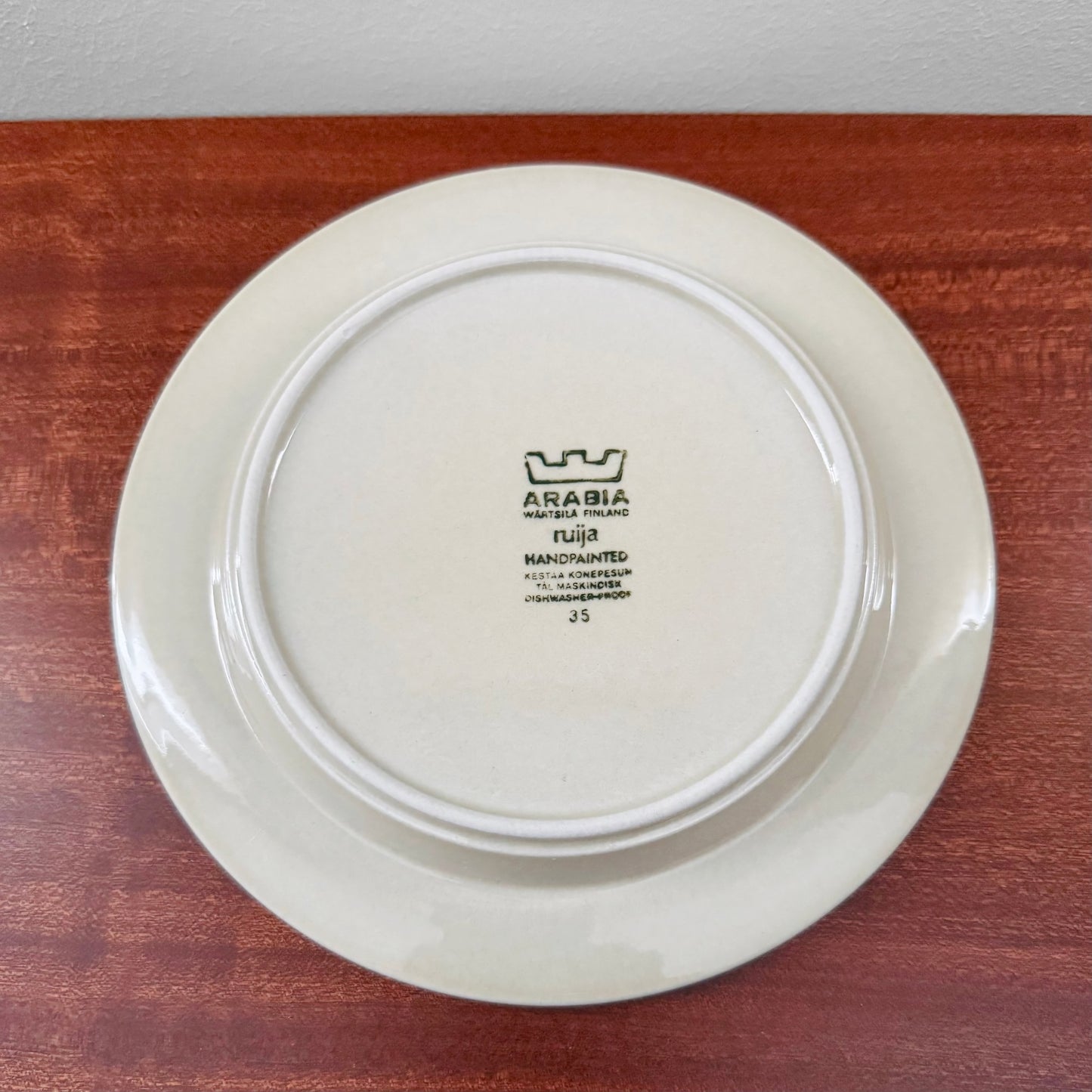 Back view of a vintage ceramic cake plate from the Arabia Finland Ruija Tea Cup Trio Set, showing the authentic maker's mark and cream-colored glaze.