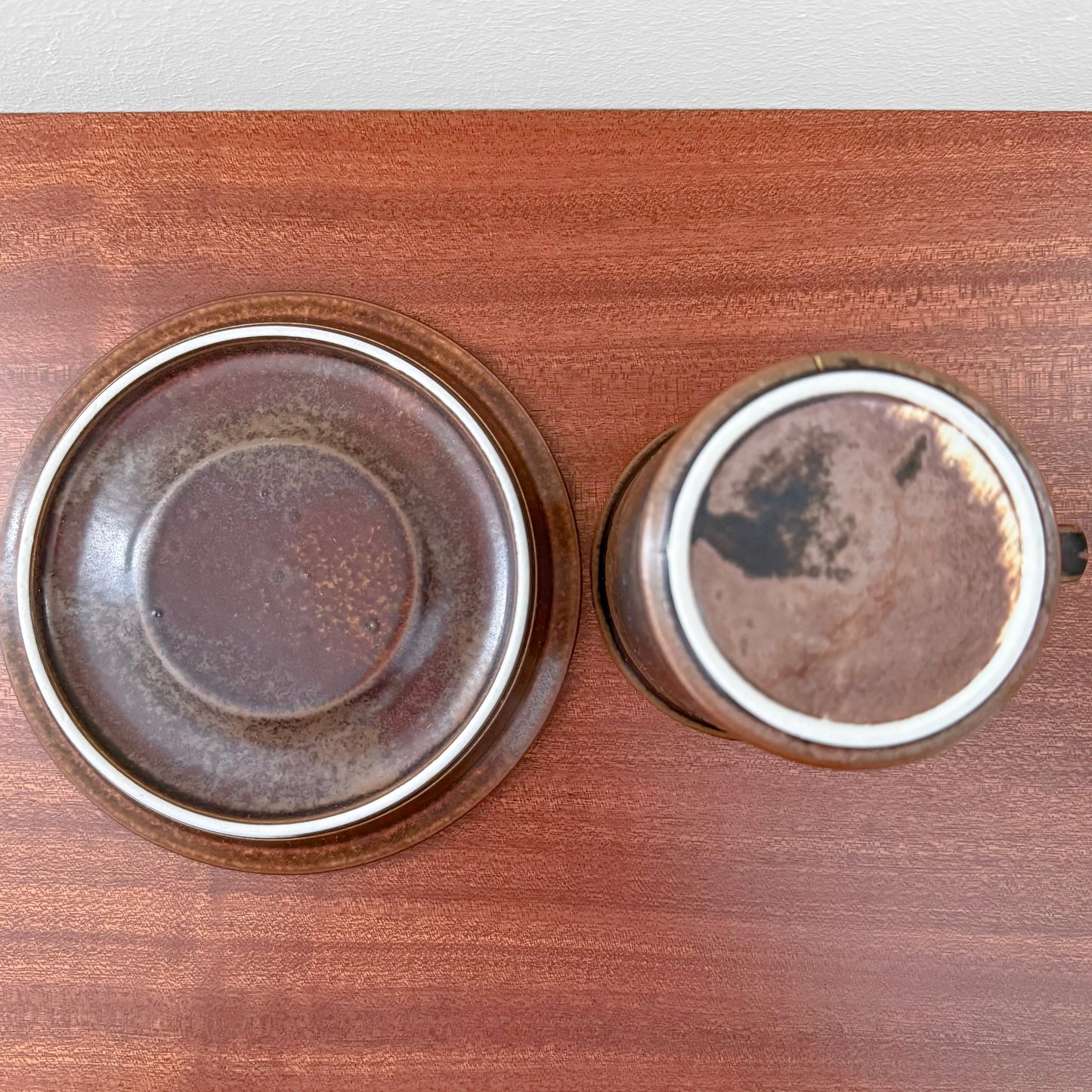 Top view of Arabia Finland Ruska Cocoa Mug with Saucer showcasing brown ceramic vintage design with textured glaze on wooden surface from Nordic Wares Store.