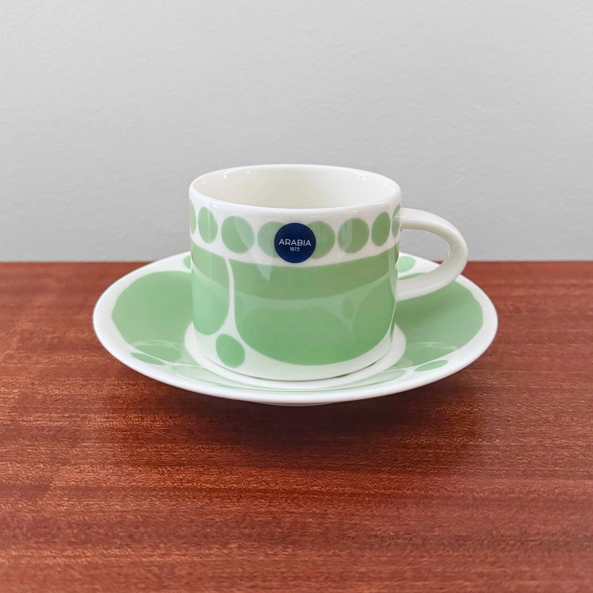 Arabia Finland Sunnuntai Green Tea Cup with Saucer featuring a vintage 1970s green and white design by Birger Kaipiainen, showcasing Nordic ceramic craftsmanship.