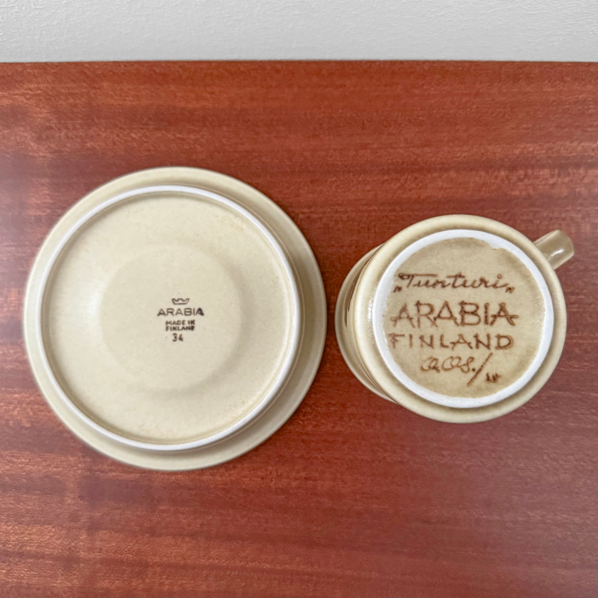 Bottom view of Arabia Finland Tunturi Coffee Cup with Saucer showing vintage maker’s marks and handwritten details on a wooden surface