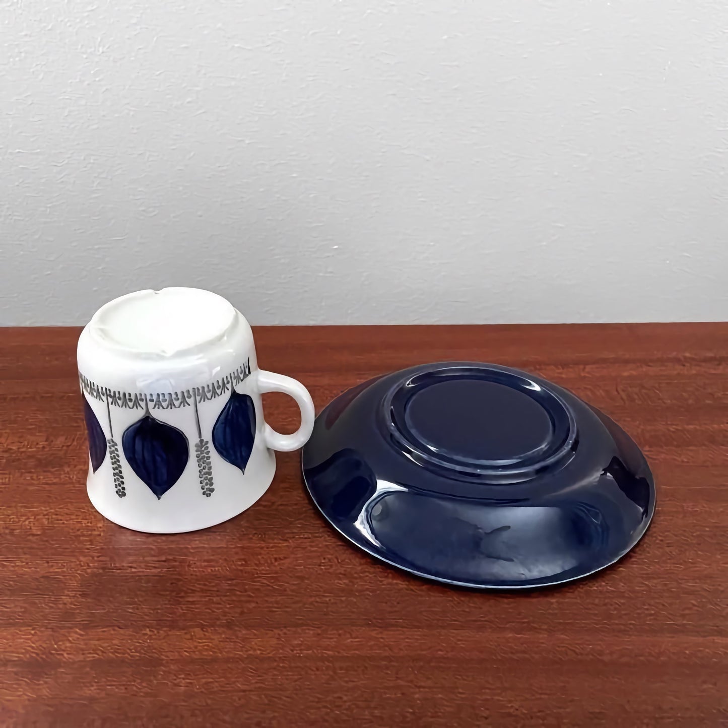 Upsala-Ekeby/Gefle Groblad Blue Coffee Cup with Saucer featuring vintage ceramic design with deep blue leaf patterns on the cup and solid blue saucer in excellent condition.