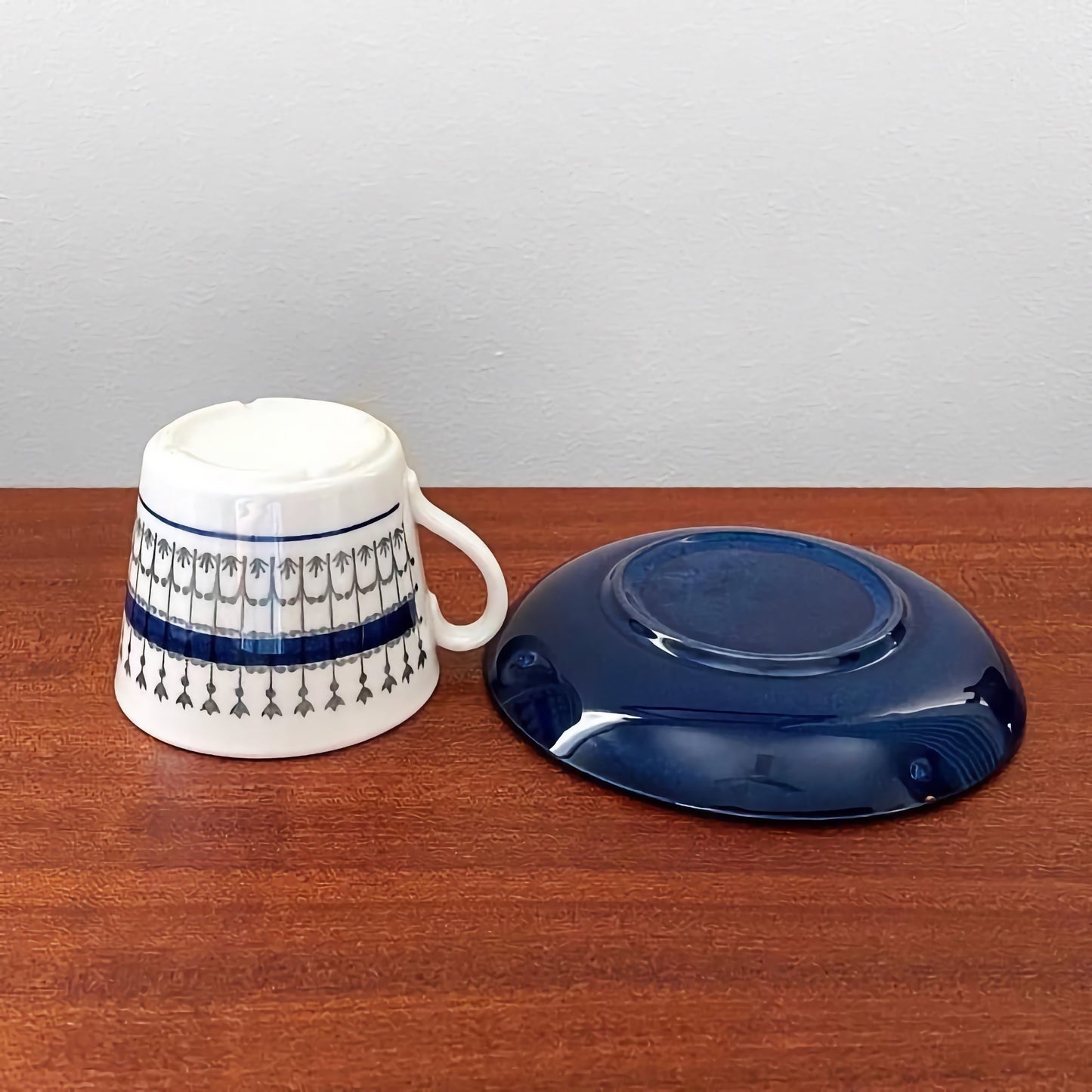 Upsala-Ekeby/Gefle Smide Blue Coffee Cup with Saucer featuring a white cup with blue and gray decorative patterns and a solid blue saucer, showcasing vintage Nordic ceramic drinkware.