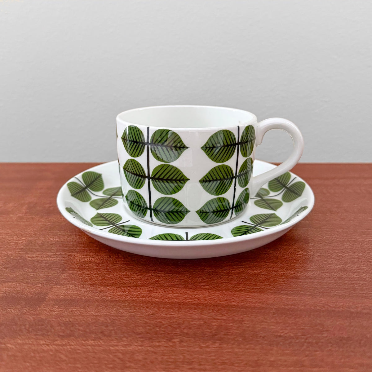 Gustavsberg Berså Tea Cup with Saucer featuring a green leaf pattern designed by Stig Lindberg, showcasing vintage Scandinavian ceramic drinkware from Nordic Wares Store.