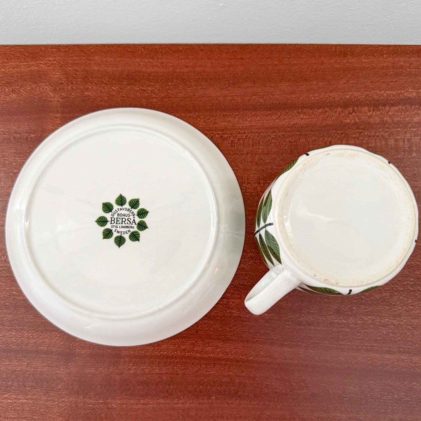 Bottom view of Gustavsberg Berså Tea Cup with Saucer showing vintage ceramic markings and green leaf motif on white Scandinavian design.