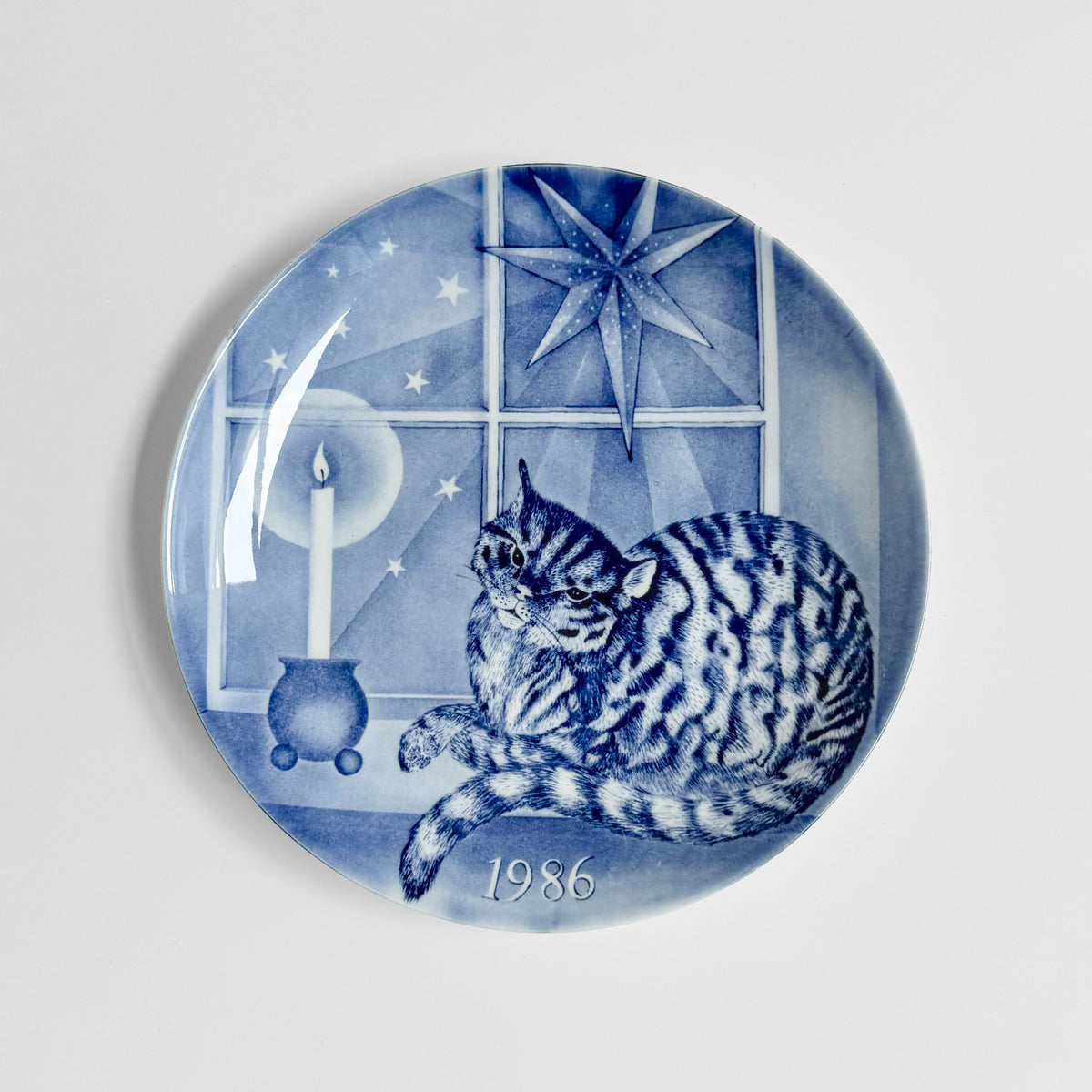 Gustavsberg Christmas Plates (1986-1994) blue and white ceramic decorative dish featuring a cat beside a candle and starry window scene marked 1986