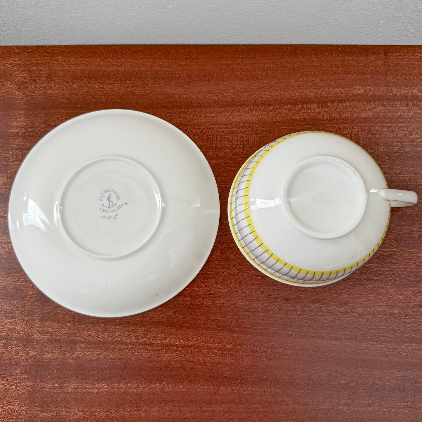 Gustavsberg Piké Tea Cup with Saucer viewed from above, showing the underside with maker’s marks on white ceramic, featuring a vintage Scandinavian design by Stig Lindberg.