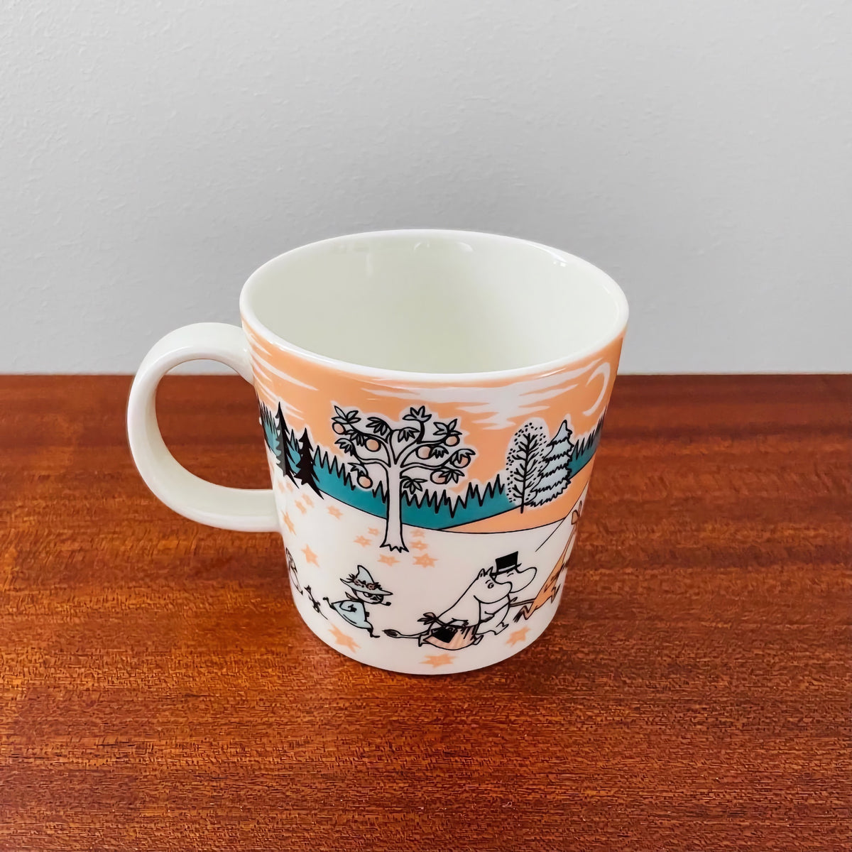 Moominvalley Park Japan Special Edition Mug (2019) featuring colorful Nordic ceramic design with Moomin characters by Arabia Finland on a wooden surface.
