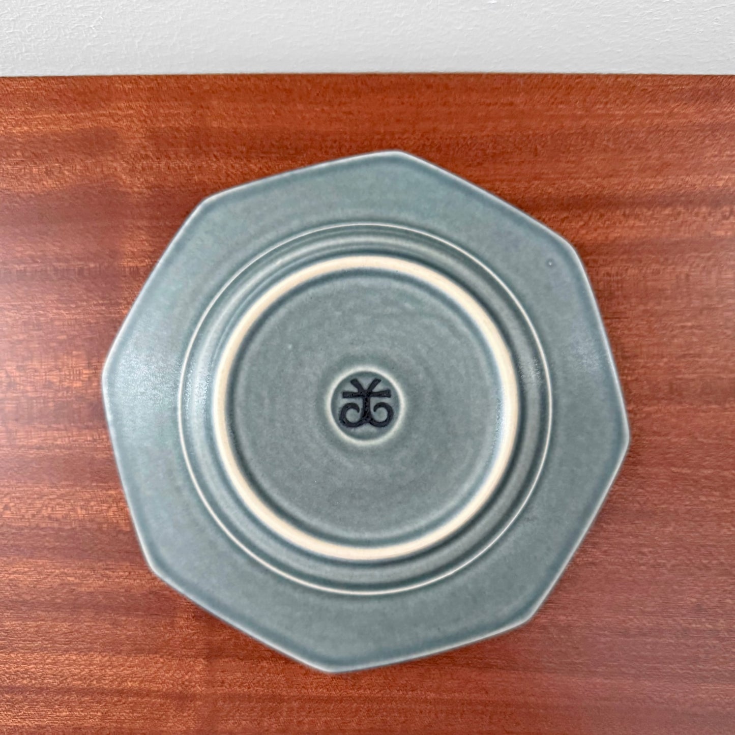 Quistgaard Azur Octagon Tea Cup Trio Set octagonal saucer in muted blue-green ceramic with subtle concentric ring detailing and a small maker's mark at the center.