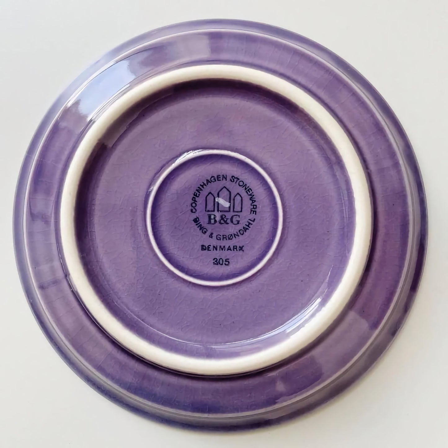 Quistgaard Cordial Palet Purple Tea Cup with Saucer showing the purple stoneware saucer bottom stamped with Bing & Grøndahl Denmark maker’s mark from 1960s Nordic ceramics.