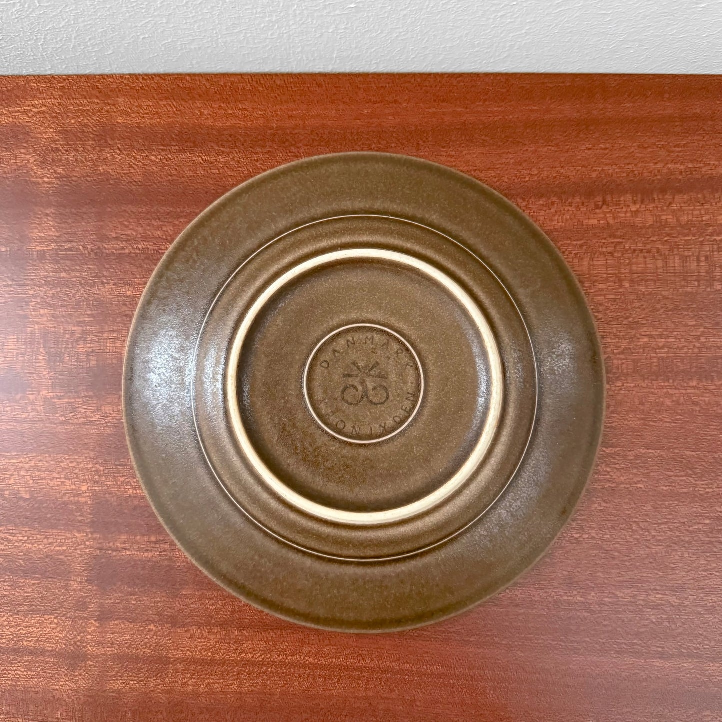 Bottom view of a brown ceramic saucer from the Quistgaard Umbra Tea Cup Trio Set, showcasing its vintage Nordic craftsmanship and textured finish.