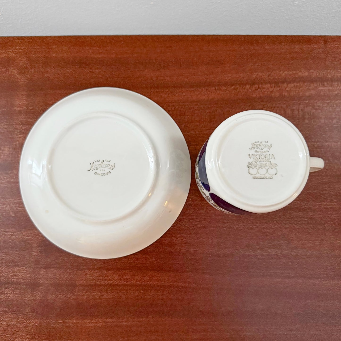 Bottom view of a Rörstrand Viktoria Coffee Cup with Saucer showing vintage ceramic maker’s marks on a wooden surface in a Nordic Wares Store setting.