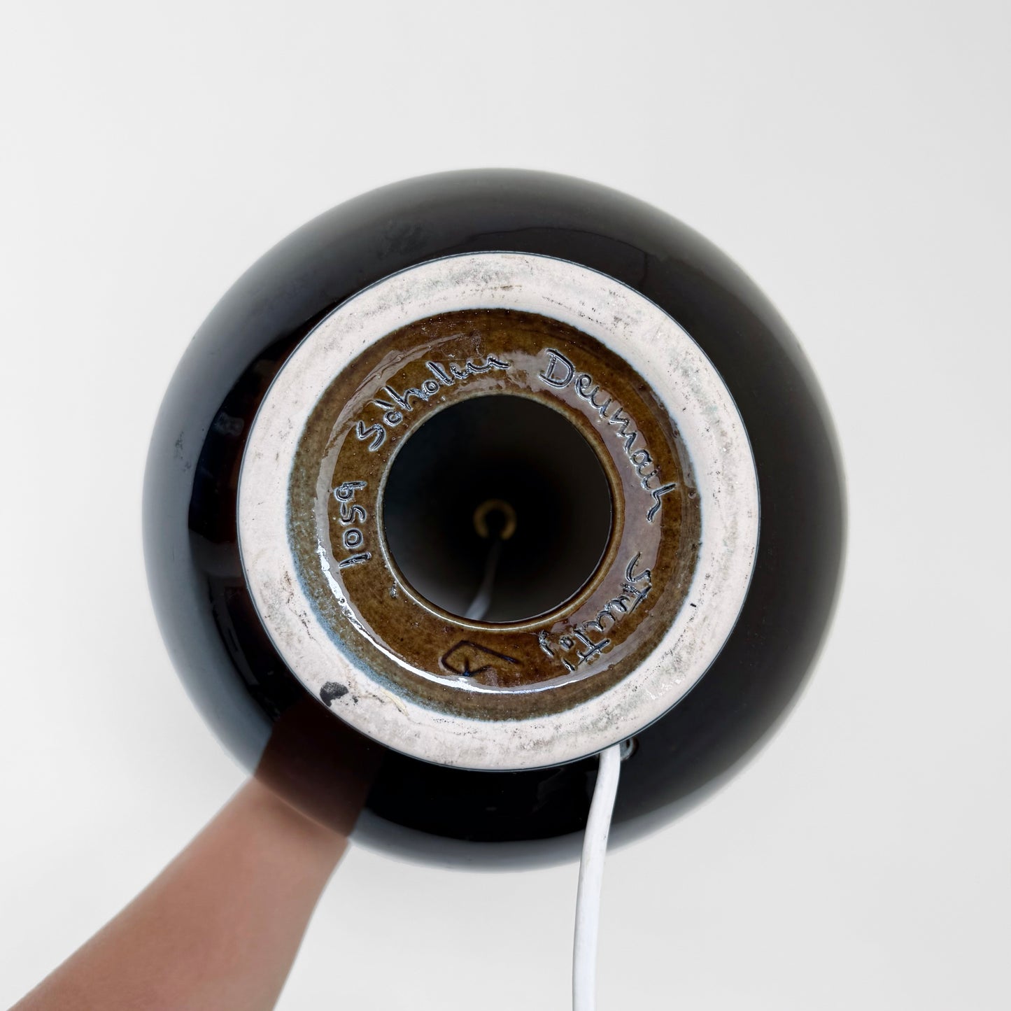 Close-up view of the underside of the Søholm 1059 Blue Stoneware Table Lamp showing the ceramic base with maker’s mark and wiring through the center.