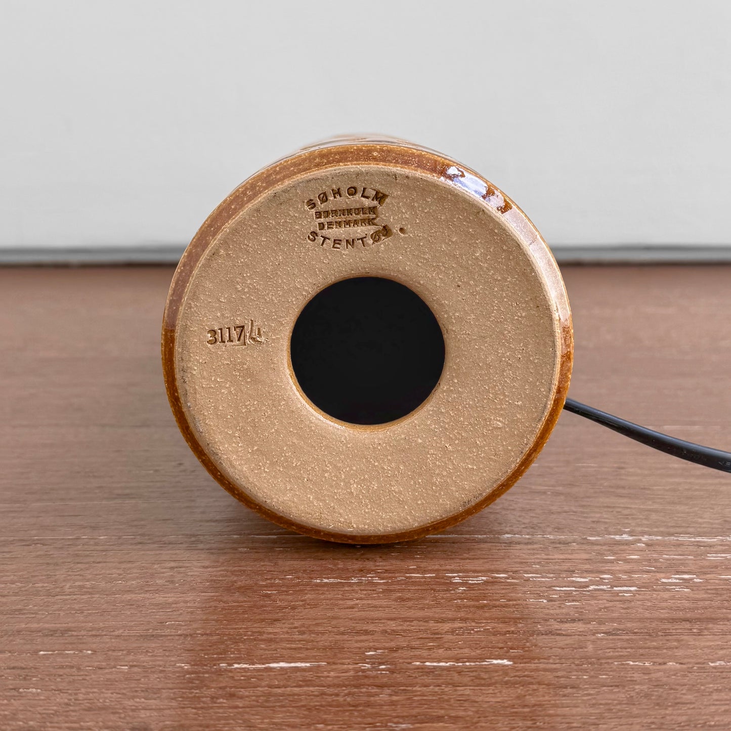 Underside of the Søholm 3117 Brown-Green Stoneware Table Lamp showing maker's stamp and model number on ceramic base against wooden surface.