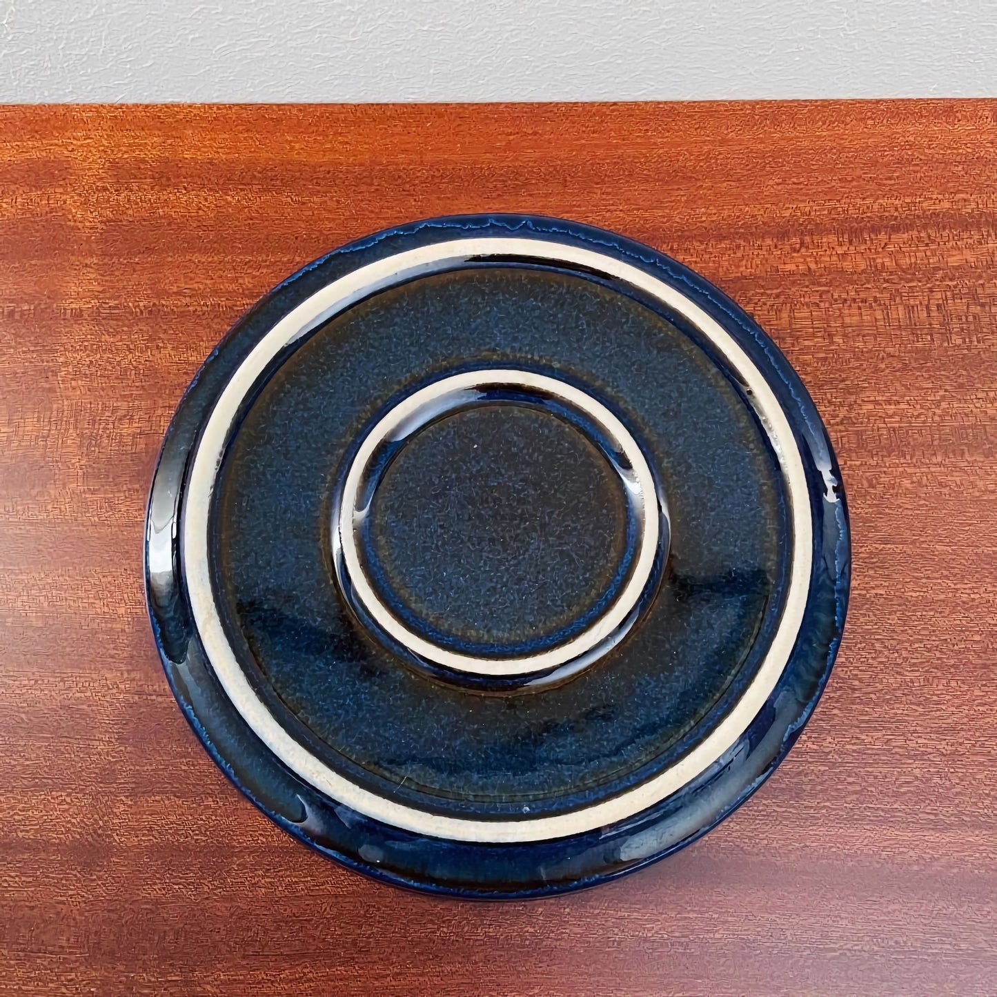 Vintage Søholm Granit Blue Tea Cup Trio Set cake plate in deep blue ceramic with light rings, showcasing Scandinavian mid-century craftsmanship on a wooden surface.