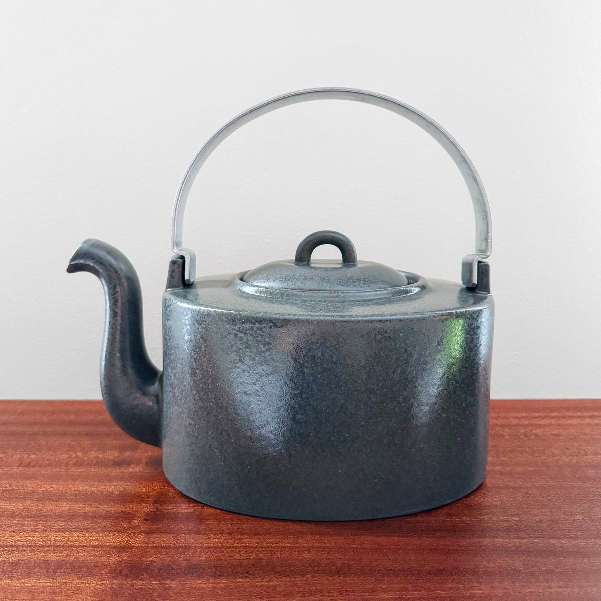 Signe Persson-Melin Design House Stockholm Grey Stoneware Teapot in a large vintage style with a curved spout and a metal handle, showcasing Scandinavian ceramic craftsmanship.