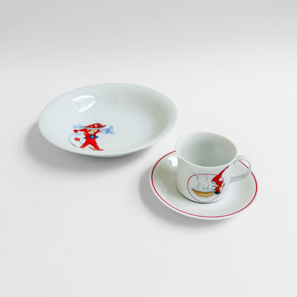 Aina Stenberg Rörstrand Tomtejul Tableware Set with vintage Swedish deep plate and coffee cup with saucer featuring festive red and blue Christmas illustrations