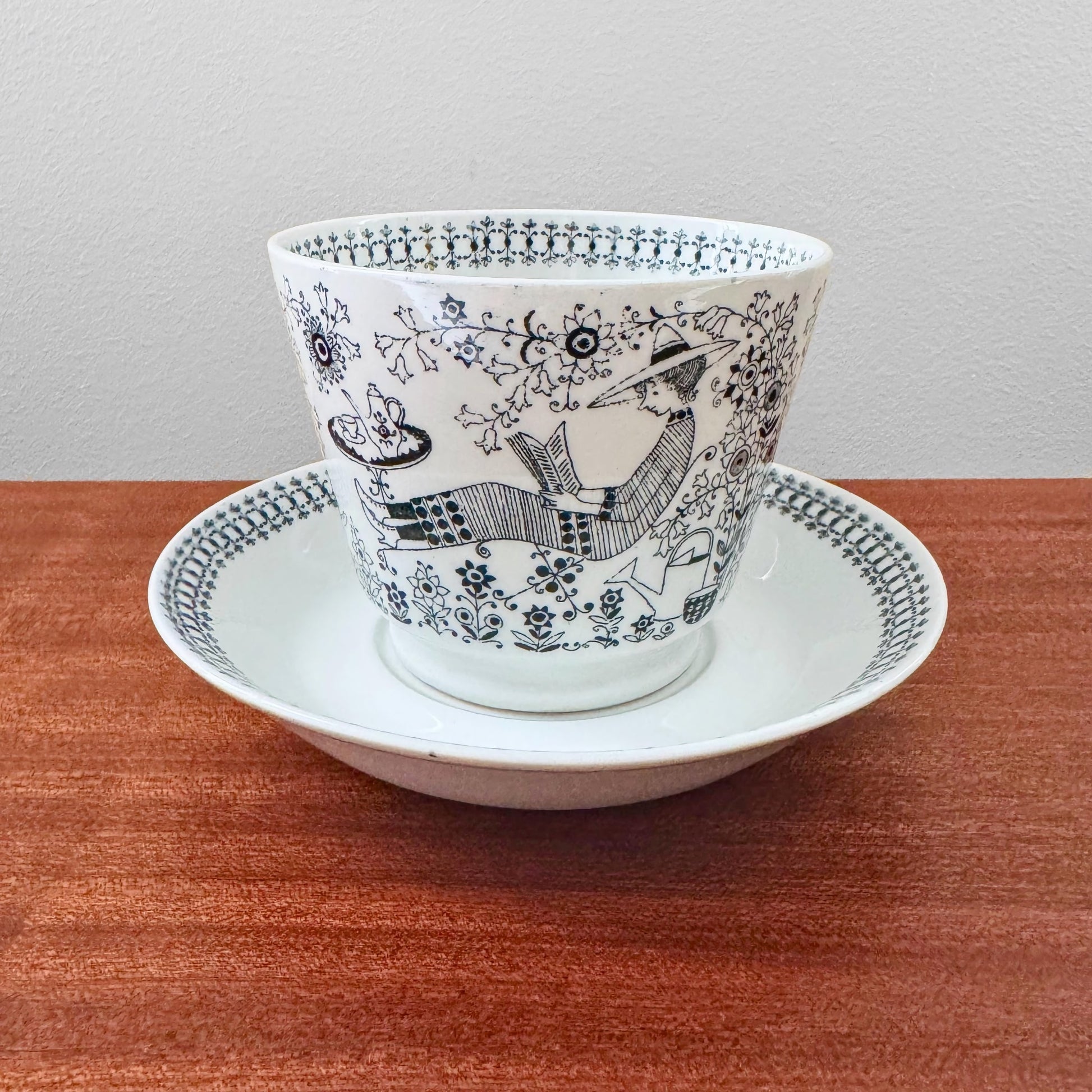 Arabia Finland Emilia Large Cocoa Cup with Saucer featuring black and white vintage illustration of a person reading under a tree, showcasing mid-century Nordic ceramic design.