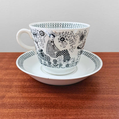 Arabia Finland Emilia Large Cocoa Cup with Saucer featuring intricate black and white mid-century design depicting seated figures and floral patterns, vintage ceramic drinkware.
