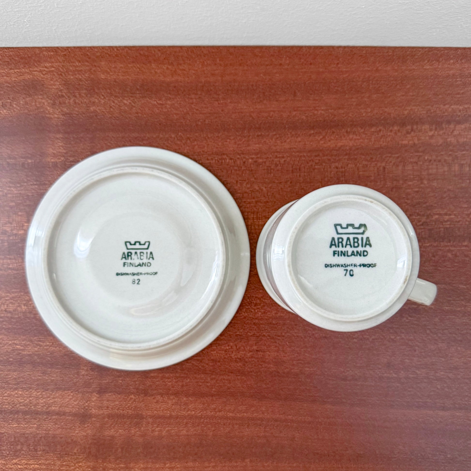Bottom view of Arabia Finland Fennica Coffee Cup with Saucer showing vintage maker's marks and Nordic ceramic craftsmanship on a wooden surface.
