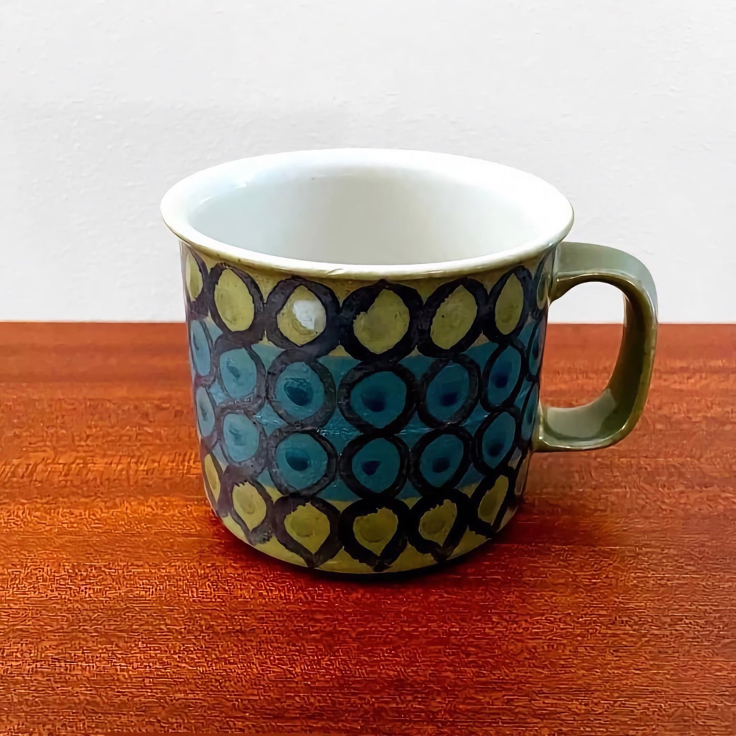Arabia Finland Hilkka-Liisa Ahola Large Green Mug featuring a vintage hand-painted circular pattern in green and blue hues, showcasing classic Nordic ceramic design.