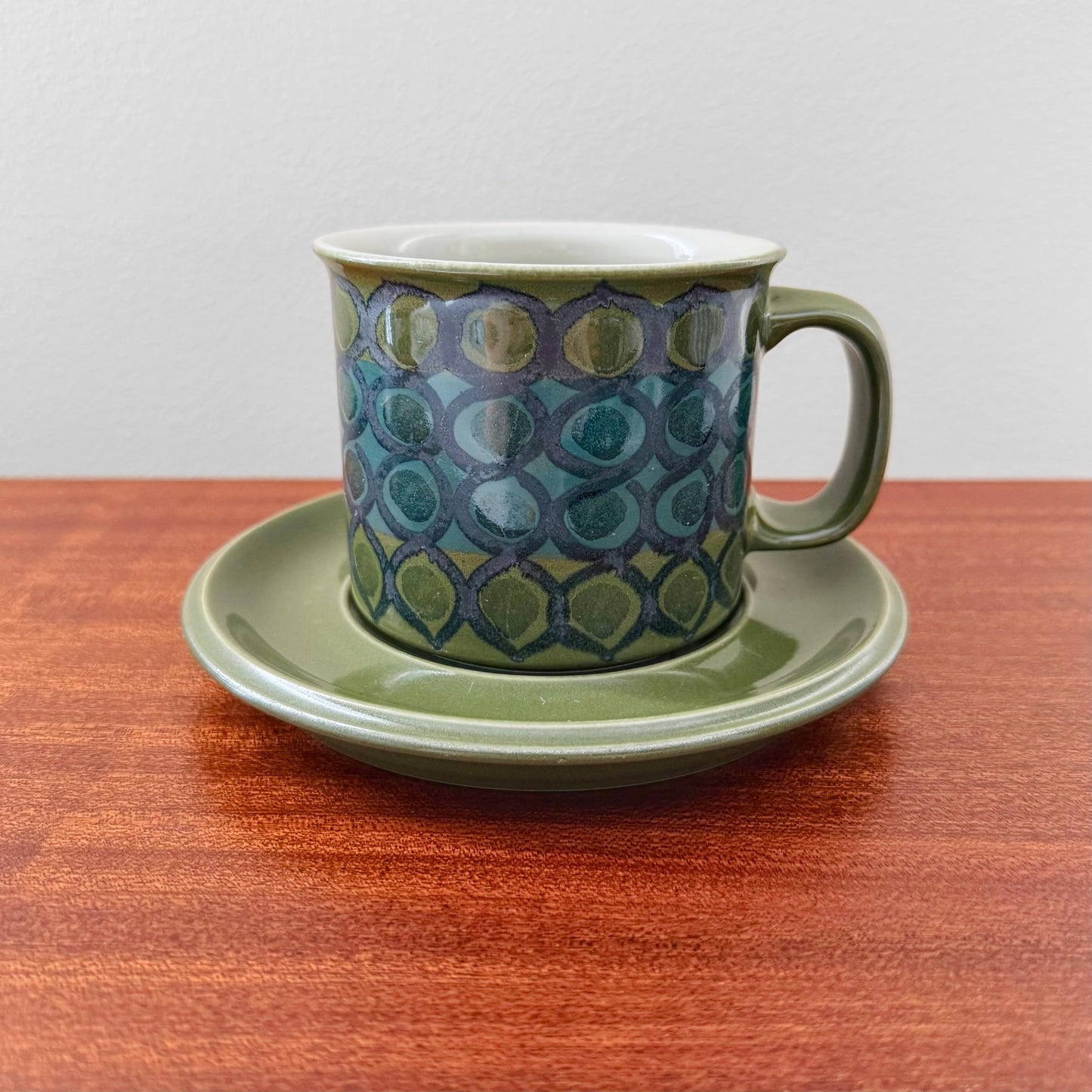Arabia Finland Hilkka-Liisa Ahola Large Green Mug with Saucer featuring a vintage hand-painted geometric pattern in green and blue tones on ceramic drinkware from Nordic Wares Store.