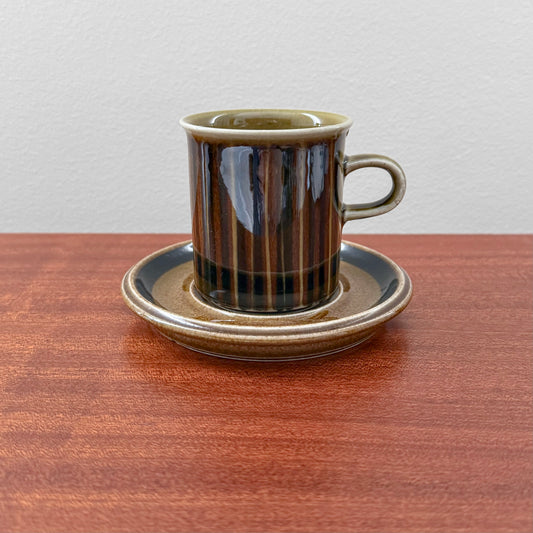 Arabia Finland Kosmos Coffee Cup with Saucer featuring a vintage brown and black striped ceramic design, showcasing classic Nordic drinkware craftsmanship on a wooden surface.