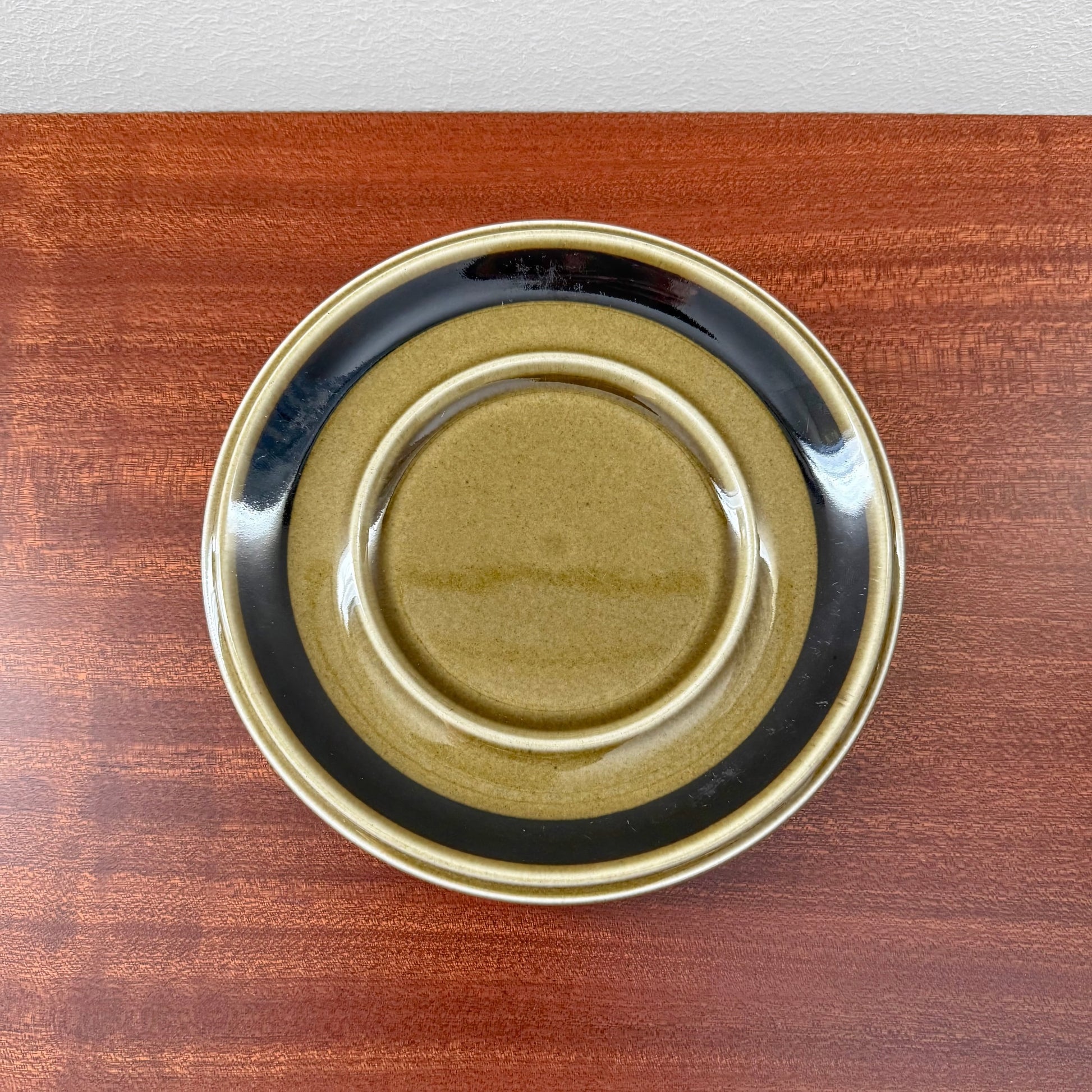 Arabia Finland Kosmos Large Mug with Saucer featuring a vintage ceramic saucer in earthy tones of olive green and black, showcasing authentic Nordic design craftsmanship.