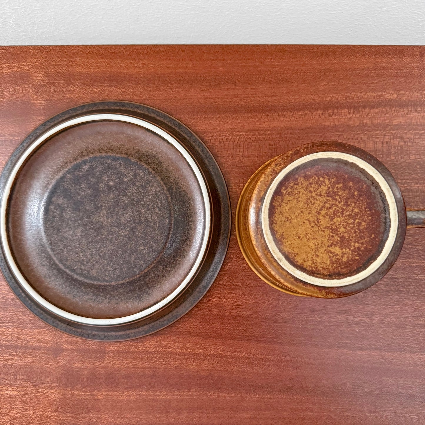 Arabia Finland Ruska Tea Cup with Saucer viewed from above, showcasing the vintage ceramic in warm brown and golden tones on a wooden surface.