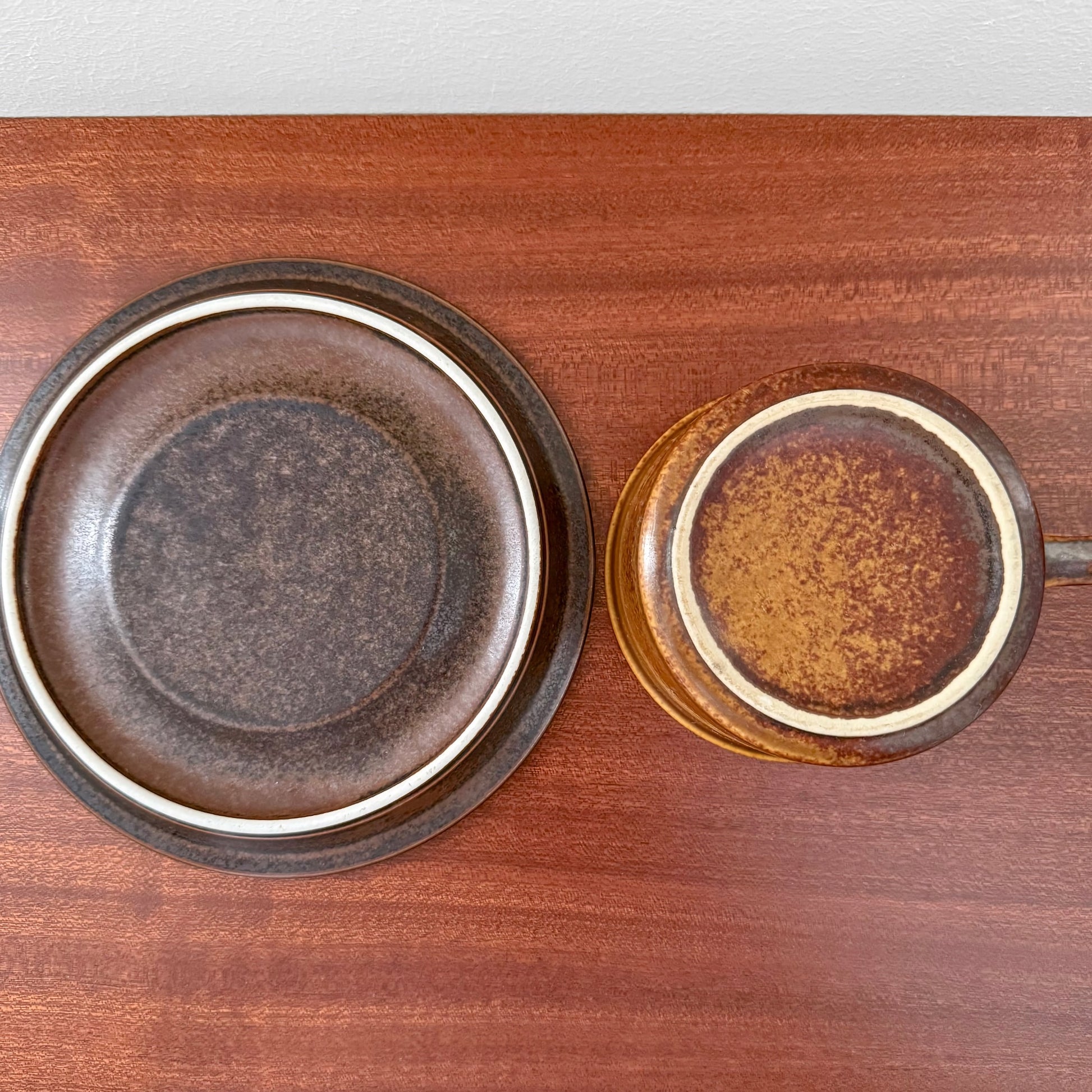 Arabia Finland Ruska Tea Cup with Saucer viewed from above, showcasing the vintage ceramic in warm brown and golden tones on a wooden surface.