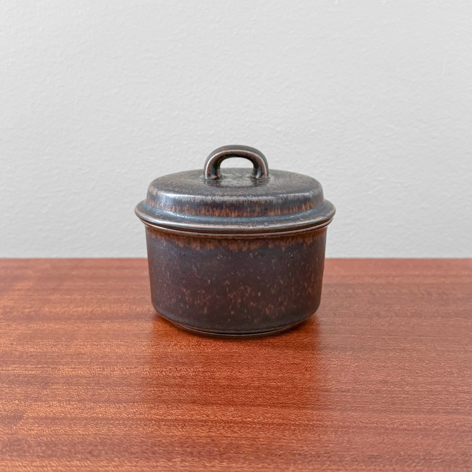 Arabia Finland Ruska Sugar Bowl in dark brown ceramic with a lid, showcasing vintage Scandinavian design by Ulla Procopé, displayed on a wooden surface.