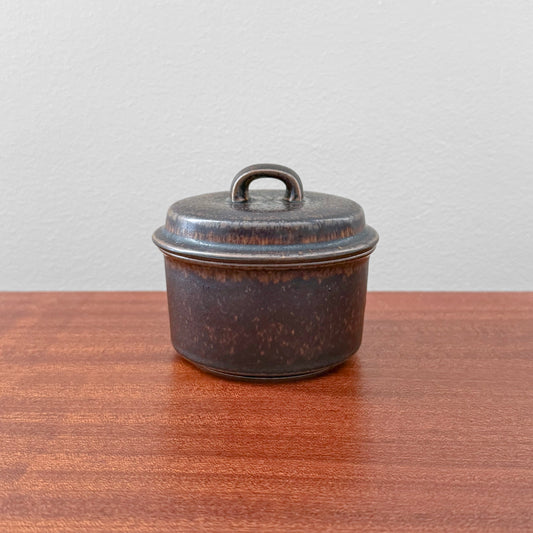 Arabia Finland Ruska Sugar Bowl in dark brown ceramic with a lid, showcasing vintage Scandinavian design by Ulla Procopé, displayed on a wooden surface.