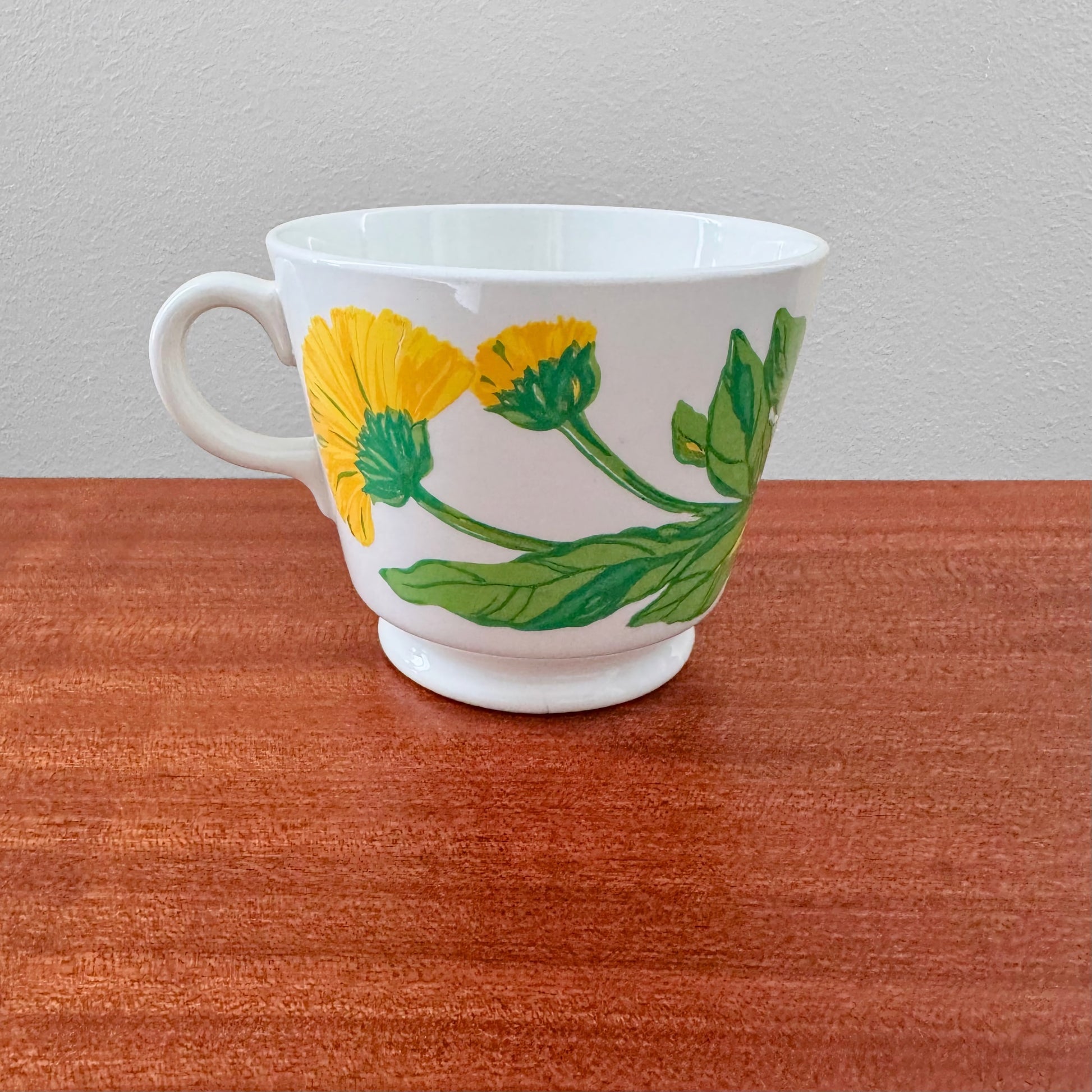 Arabia Finland Suvi Large Cocoa Cup featuring yellow floral pattern and green leaves on white ceramic, showcasing vintage Nordic ceramics from the 1970s.