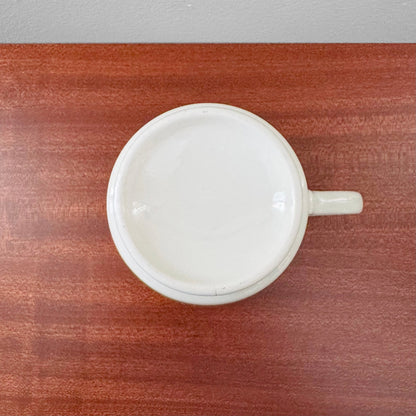 Arabia Finland Suvi Large Cocoa Cup shown from above on a wooden surface, featuring simple white ceramic design and a single handle.