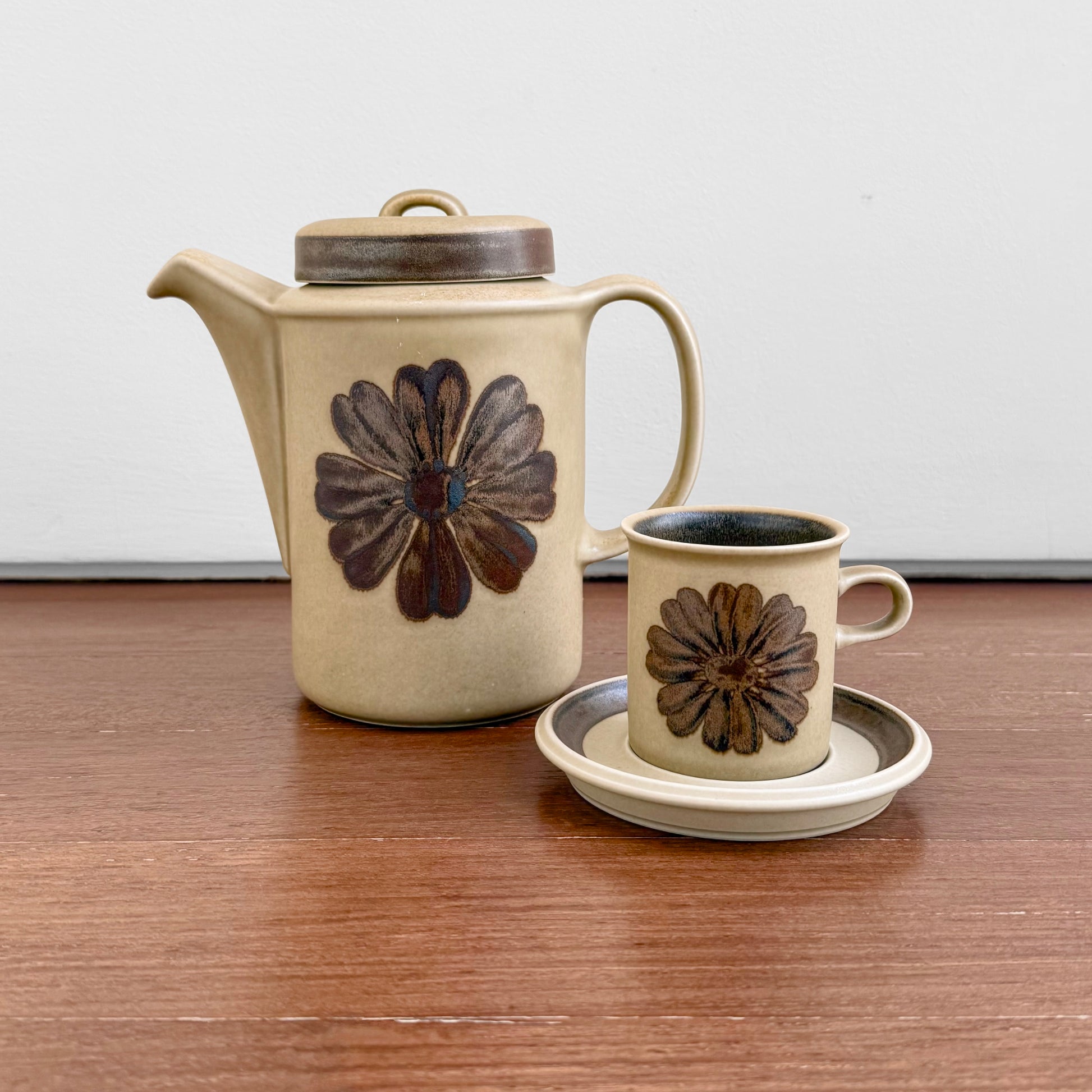 Vintage Arabia Finland Tunturi Coffee Set featuring a ceramic coffee pot and matching cup with saucer, decorated with brown floral designs on a beige background.
