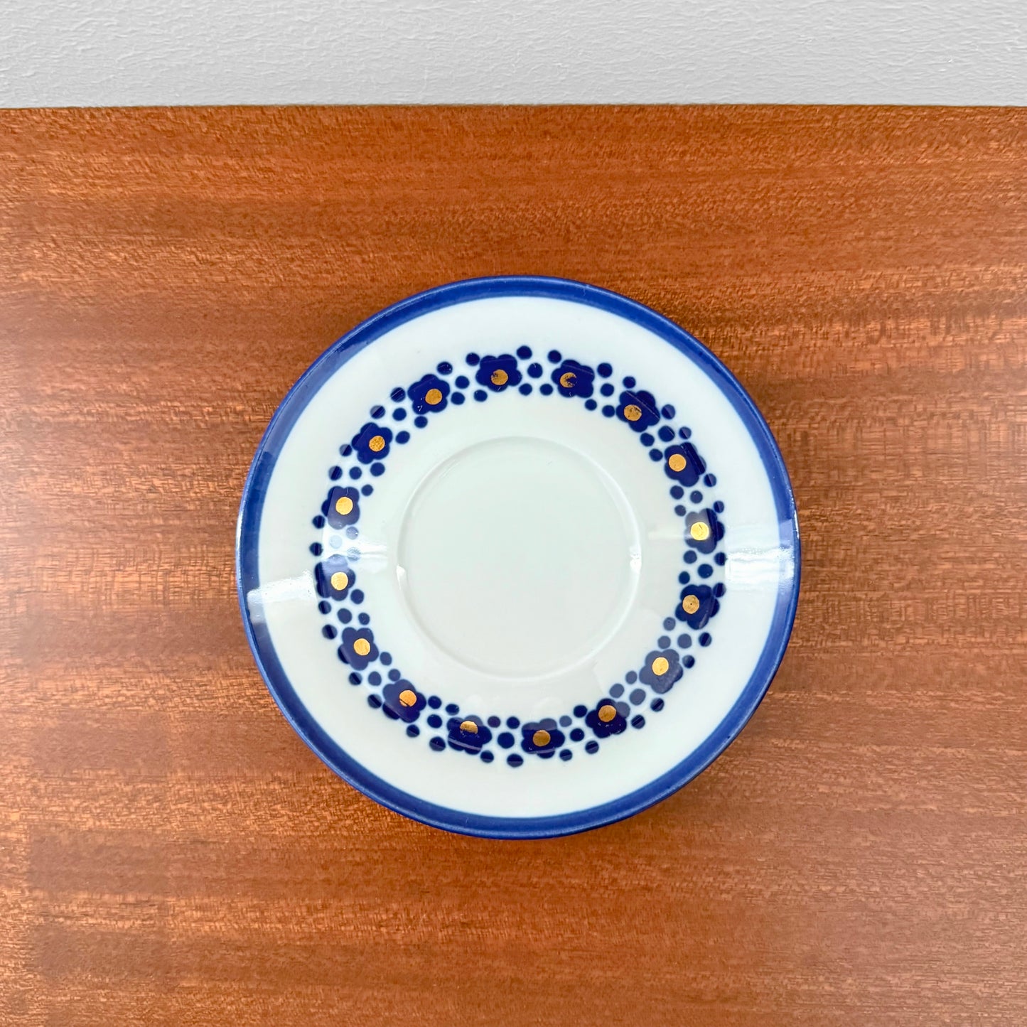 Arabia Finland Virva Espresso Cup with Saucer featuring a vintage 1970s blue floral pattern on white ceramic, displayed on a wooden surface, showcasing Nordic craftsmanship.