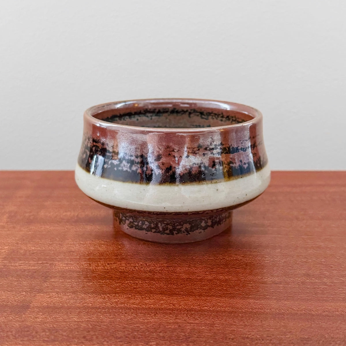 Carl-Harry Stålhane Designhuset Stoneware Decorative Bowl with brown, black, and white glazed ceramic, vintage Scandinavian craftsmanship, displayed on a wooden surface in a minimalist setting.