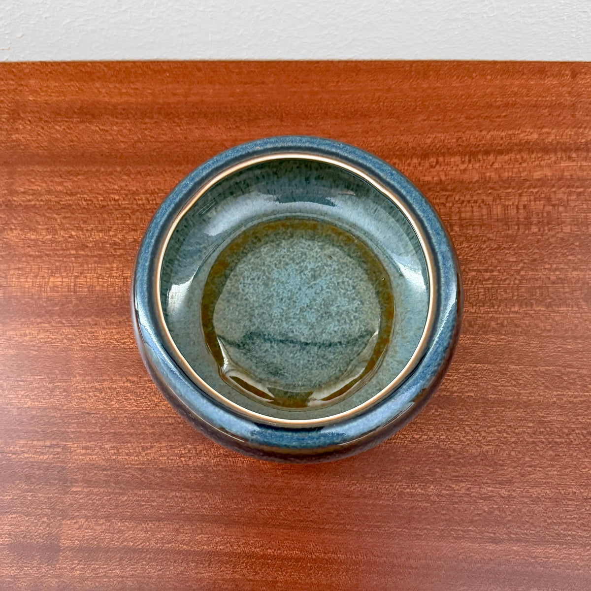 Carl-Harry Stålhane Rörstrand SAB Stoneware Decorative Bowl in blue glaze with a rounded, deep design, showcasing vintage Nordic craftsmanship on a wooden surface.