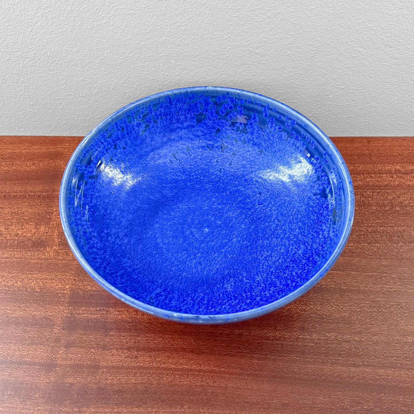 Danish Cobalt Blue Stoneware Decorative Bowl in vivid blue glaze on a wooden surface showcasing a rounded form and glossy finish for Nordic home decor
