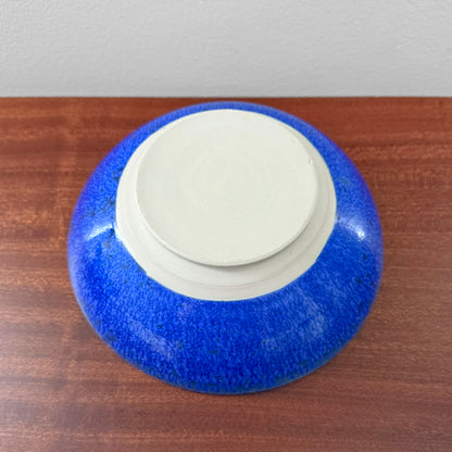 Danish Cobalt Blue Stoneware Decorative Bowl shown from the underside with vivid blue glaze and a raised unglazed base on a wooden surface
