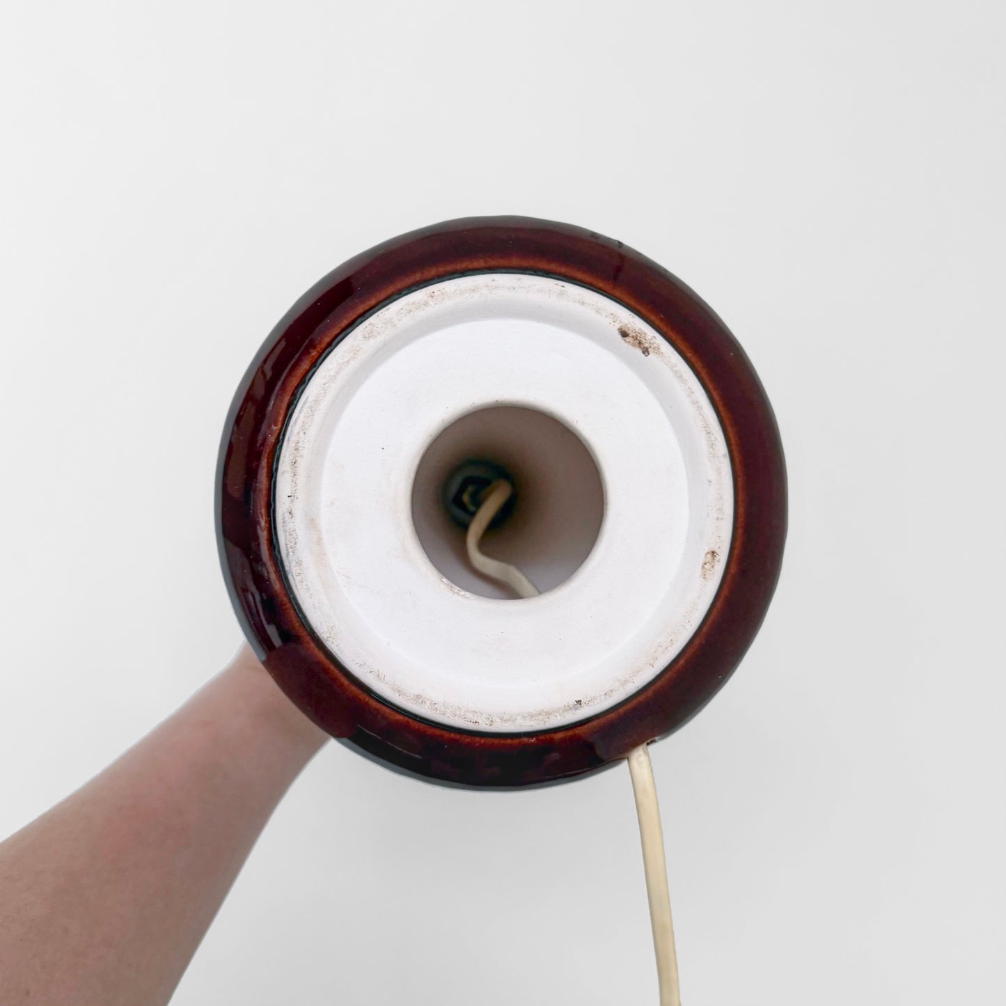 Top-down view of a vintage ceramic Danish Red Stoneware Table Lamp with a deep red glaze, showing the electrical socket and cord inside the base.