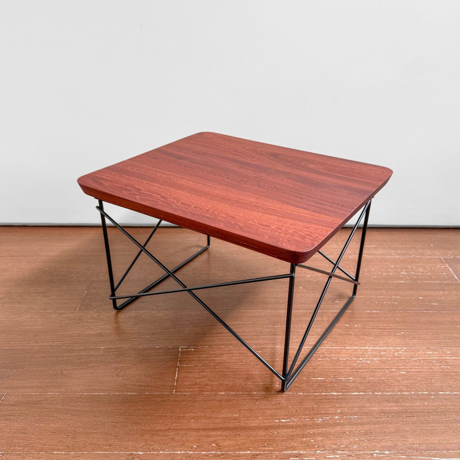 Eames Eucalyptus LTR Table featuring a solid eucalyptus wood top with natural knots and a black powder-coated wire base, showcasing a blend of Nordic design and craftsmanship.