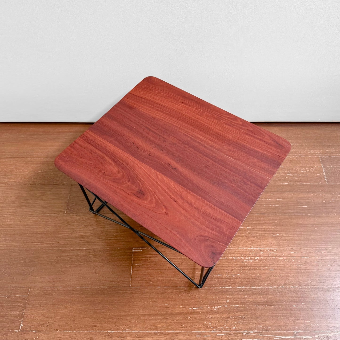 Eames Eucalyptus LTR Table featuring a solid eucalyptus wood top with natural knots and black powder-coated wire base, presented in a minimalist Nordic design style.