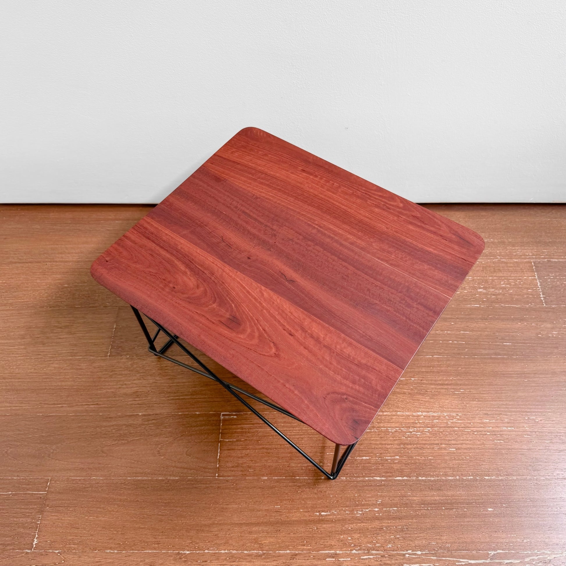 Eames Eucalyptus LTR Table featuring a solid eucalyptus wood top with natural knots and black powder-coated wire base, presented in a minimalist Nordic design style.