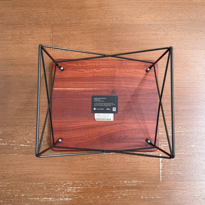 Overhead view of the Eames Eucalyptus LTR Table showing its solid eucalyptus wood top with natural knots and cracks, supported by a black powder-coated wire base on a wooden floor.