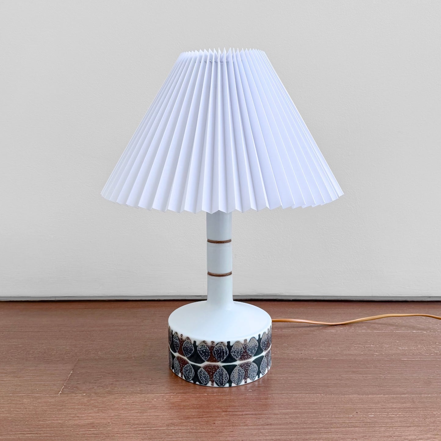 Ellen Malmer Royal Copenhagen Baca White Table Lamp (638/3480), ceramic table lamp with brown abstract motif and pleated white shade.