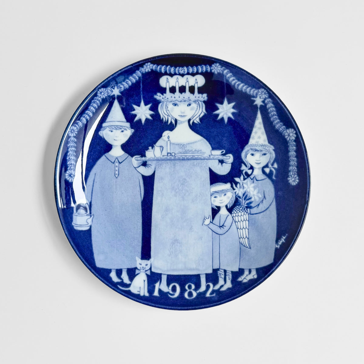 Gustavsberg Christmas Plates (1981-1985) blue and white decorative dish by Stig Lindberg showing a festive Nordic Christmas scene with children and candles